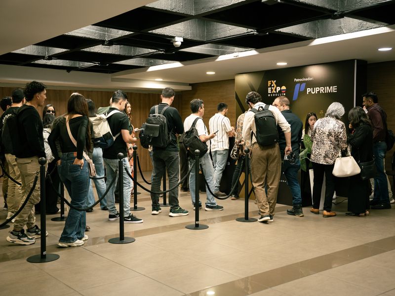 Des participants font la queue devant le panneau PU Prime